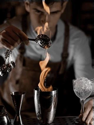 A bartender flaming a cocktail
